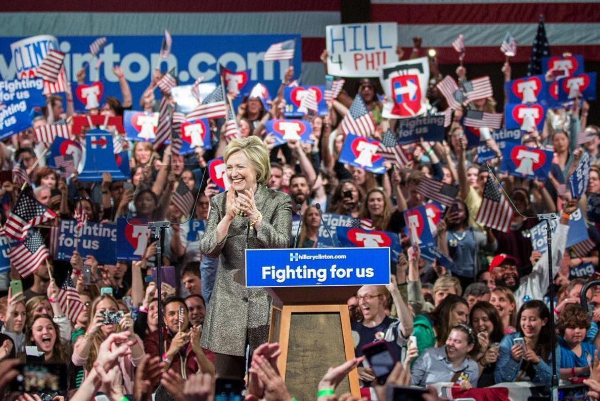 Hillary Clinton at rally in front of large crowd with signs